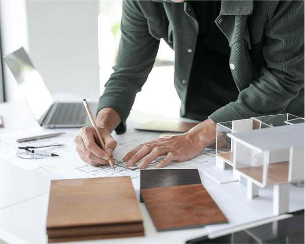 Architect drafting plans at a desk.